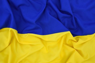 Ukrayna 'nın ulusal bayrağını büktü. Mavi ve sarı renkler. Yakın plan, arkaplan.