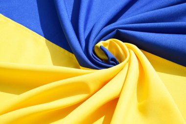 Ukrayna 'nın ulusal bayrağını büktü. Mavi ve sarı renkler. Yakın plan, arkaplan.