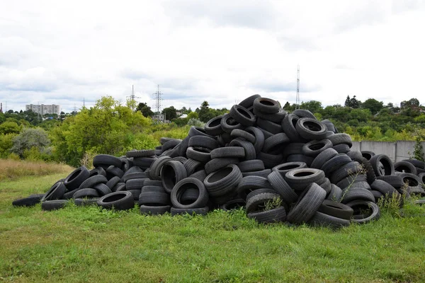 A pile of used car tires for recycling. Lots of old wheel tires in a landfill.
