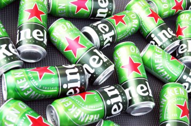 KHARKIV, UKRAINE - 1 Ağustos 2021: Birçok Heineken alkollü birası gri arka planda yatar. Heineken, Hollanda 'nın en büyük ve dünyanın en büyük ikinci bira şirketidir..