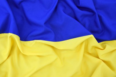 Ukrayna 'nın ulusal bayrağını büktü. Mavi ve sarı renkler. Yakın plan, arkaplan.