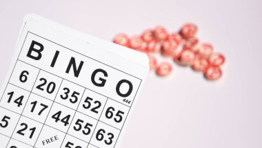 Masa başı bingo ya da loto oynamak için arka planda numaraları ve kartları olan bir sürü tahta fiş. Rus Lotosu 'nun dünya çapında klasik bingo oyunlarına benzer kuralları vardır..