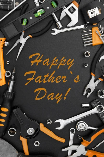 Lettering Happy Father\'s Day with many different tools for repair work on a black table. Father\'s day concept.