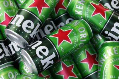 KHARKIV, UKRAINE - 1 Ağustos 2021: Birçok Heineken alkollü birası gri arka planda yatar. Heineken, Hollanda 'nın en büyük ve dünyanın en büyük ikinci bira şirketidir..