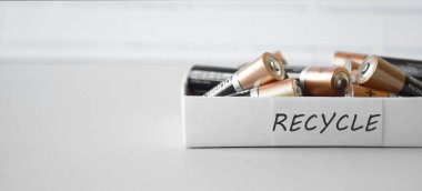 KHARKIV, UKRAINE - 22 Şubat 2022: Kullanılmış AA bataryalar ve çevresel ve toprak zehirli bataryaların mavi arka planda düzgün bir şekilde imha edilmesi. Zararlı ve geri dönüşümlü nesnelerin işlenmesi kavramı.