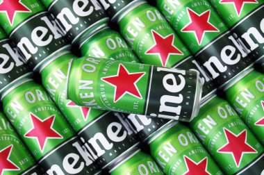 KHARKIV, UKRAINE - 1 Ağustos 2021: Birçok Heineken alkollü birası gri arka planda yatar. Heineken, Hollanda 'nın en büyük ve dünyanın en büyük ikinci bira şirketidir..