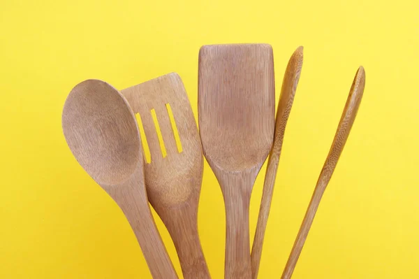 A set of bamboo dishes on a bright yellow background. Cooking concept.