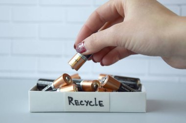 KHARKIV, UKRAINE - 22 Şubat 2022: Kullanılmış AA bataryalar ve çevresel ve toprak zehirli bataryaların mavi arka planda düzgün bir şekilde imha edilmesi. Zararlı ve geri dönüşümlü nesnelerin işlenmesi kavramı.