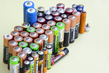 KHARKIV, UKRAINE - 11 Haziran 2022: Kullanılmış AA bataryalar ve yeşil zemin üzerinde çevresel ve toprak toksik bataryaların uygun şekilde imha edilmesi. Zararlı ve geri dönüşümlü nesnelerin işlenmesi kavramı.