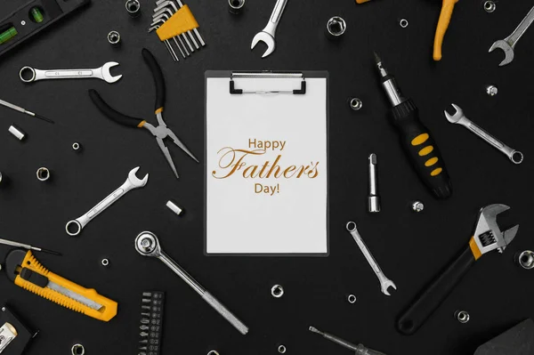 Lettering Happy Father\'s Day with many different tools for repair work on a black table. Father\'s day concept.