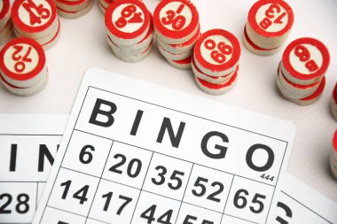 Masa başı bingo ya da loto oynamak için arka planda numaraları ve kartları olan bir sürü tahta fiş. Rus Lotosu 'nun dünya çapında klasik bingo oyunlarına benzer kuralları vardır..