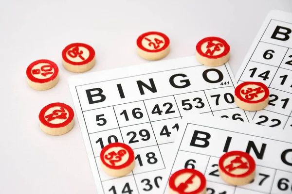 Many wooden chips with numbers and cards for a board game of bingo or lotto on a light background. Russian Lotto has similar rules to the classic worldwide bingo game.