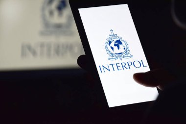 Kharkiv, Ukrayna - 16 Haziran 2022: İnterpol logosu ekranda gösterilen akıllı telefonu tutan kişi. Uluslararası Suç Polis Örgütü veya Interpol.
