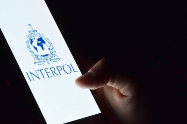 Kharkiv, Ukrayna - 16 Haziran 2022: İnterpol logosu ekranda gösterilen akıllı telefonu tutan kişi. Uluslararası Suç Polis Örgütü veya Interpol.