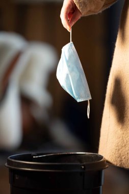 Çöp kutusunda maske, çöp, çöp ve çöp. Avustralya 'da bir güvenlik maskesi kirletmek 