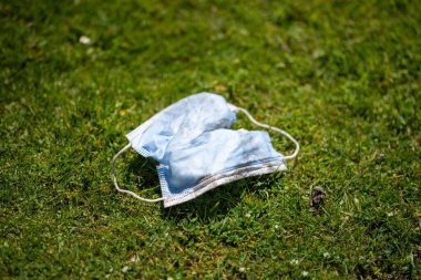 Çimlerin üzerinde tıbbi maske.