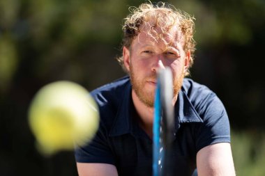 Sakallı ve beyzbol topu olan genç bir adamın portresi.