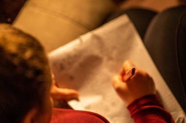 Kadın iç mekanda kitap okuyor.