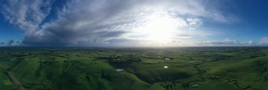 Nehir ve çimlerle kaplı bir havacılık arazisi. Sahilde sığır çiftliği ve deniz kenarında. Okyanus kıyısında ot otlayan ineklerle birlikte tarım.