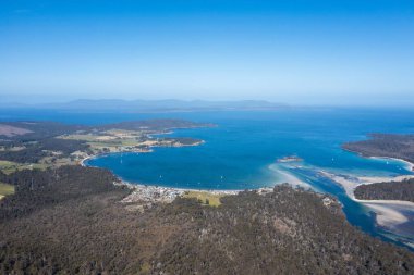 Nehir ve çimlerle kaplı bir havacılık arazisi. Sahilde sığır çiftliği ve deniz kenarında. Okyanus kıyısında ot otlayan ineklerle birlikte tarım.