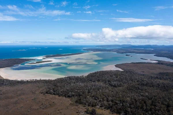 Nehir ve çimlerle kaplı bir havacılık arazisi. Sahilde sığır çiftliği ve deniz kenarında. Okyanus kıyısında ot otlayan ineklerle birlikte tarım.