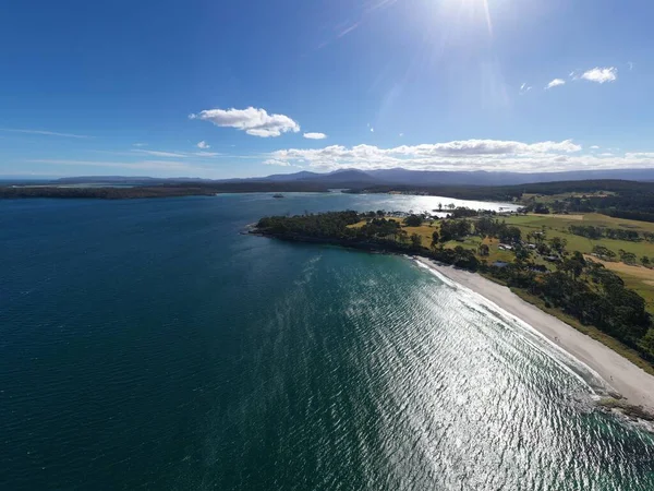 Nehir ve çimlerle kaplı bir havacılık arazisi. Sahilde sığır çiftliği ve deniz kenarında. Okyanus kıyısında ot otlayan ineklerle birlikte tarım.