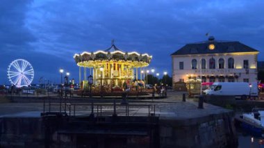 Honfleur, Fransa - 28 Temmuz 2021: Honfleur, Normandiya 'daki belediye binasının önünde mavi saatte aydınlatılmış atlıkarınca