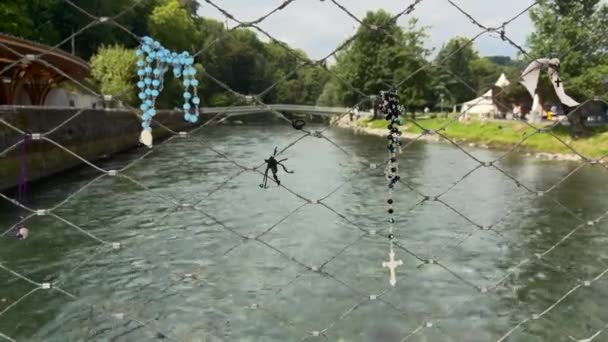ルルド フランス 2021年8月28日 ロザリオはルルドの川の上の橋の手すりにかかっています — ストック動画