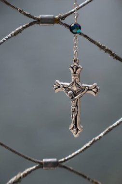 Metal Haç ve gri arka planda çarmıha gerilmiş İsa.