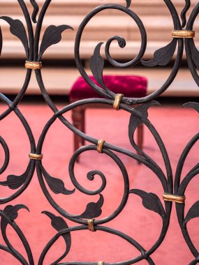 İsviçre 'deki Saint-Ursanne kilisesindeki parmaklıkların arkasında kırmızı kadifeli boş bir sandalye.