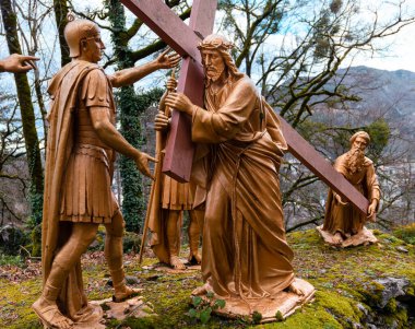 Lourdes, Fransa - 5 Ocak 2022: Lourdes Haçı yolu - 5. İstasyon: Cyrene 'li Simon haçı İsa' nın arkasında taşıyor