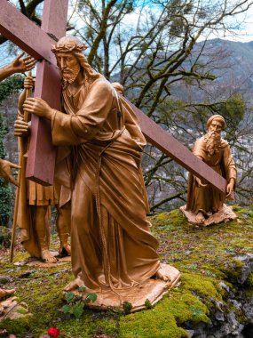 Lourdes, Fransa - 5 Ocak 2022: Lourdes Haçı yolu - 5. İstasyon: Cyrene 'li Simon haçı İsa' nın arkasında taşıyor