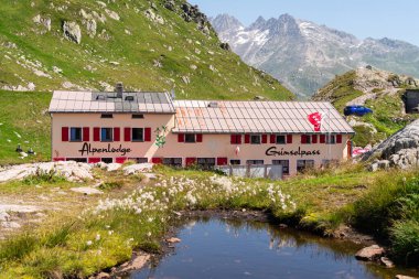 Grimselpass, İsviçre - 13 Ağustos 2021: Grimselpass 'taki Alpine Lodge Berghotel, İsviçre' de bir dağ geçidi, Bernese Alplerini 2164 metre yükseklikte geçiyor..