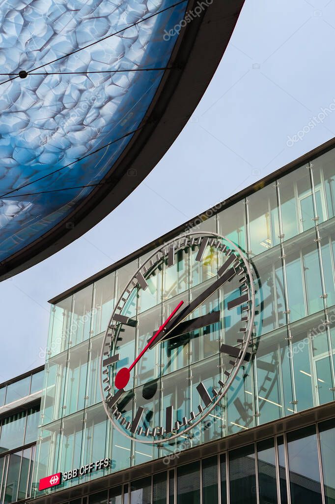 Aarau, Switzerland - November 3, 2021: SBB watch and modernly designed blue roof of a bus station in Aarau