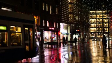 Zürih, İsviçre - 1 Aralık 2021: Geceleyin Zürih 'te Bahnhofstrasse alışveriş caddesi aydınlandı ve bir tramvay geçti..