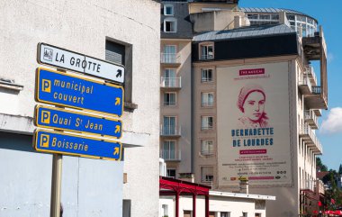 Lourdes, Fransa - 28 Ağustos 2021: Lourdes ve park yerlerindeki hayalet mağaralarının yönünü gösteren işaretler.
