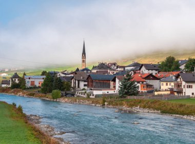 River Inn ve İsviçre 'nin Graubunden kantonundaki Maloja Bölgesi' nin Zuoz köyü. Idyllic sonbahar sisli havası,