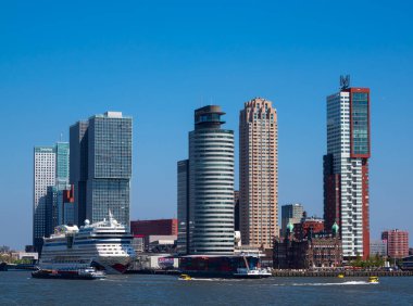 Rotterdam, Hollanda - 28 Nisan 2022: Rotterdam 'ın gökdelenlerinin yanında demirli turist kruvazörü Aida