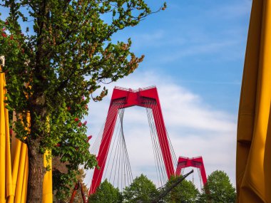 Rotterdam, Hollanda - 28 Nisan 2022: Willemsbrug 'da bir manzara, toplam uzunluğu yaklaşık 318 metre olan kablo ile kırmızı bir köprü.