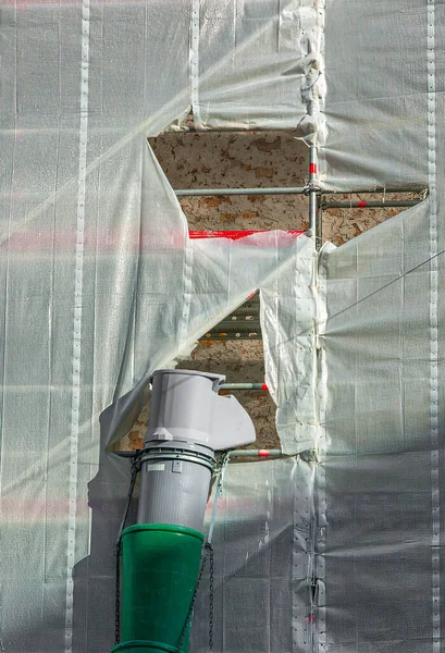 Ön cephe ve bina yenilenirken atık maddelerin taşınması için plastik tüp.