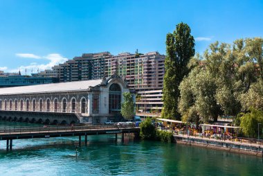 Cenevre, İsviçre - 3 Haziran 2022: Konut binaları ve Cenevre 'de Usine des Forces Motrices adlı eski bir hidroelektrik santrali ve Rhone Nehri üzerindeki su tesislerinin elektrik santrali.