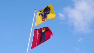 Flags at the border of cantons Uri (yellow flag) and Glarus (red flag) at Klausenpass in Switzerland