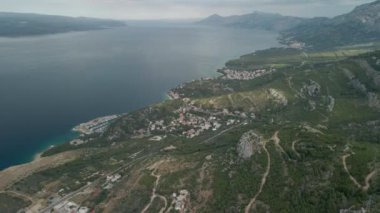 Hırvatistan 'ın Makarska Riviera bölgesindeki bir dağ yolu ve küçük bir kıyı kasabası olan Krvavica' nın insansız hava aracı manzarası, arka planda Adriyatik kıyıları ve Brac adası bulunuyor..