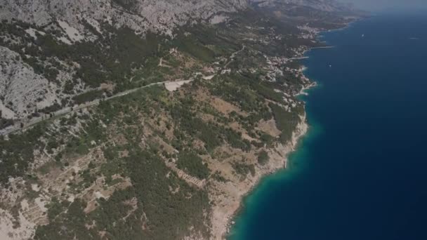 Adembenemende uitzichten vanaf de hoogte van de Kroatische kust in de Makarska Riviera. Uitzicht vanuit de lucht op de weg, bergen, stranden en nederzettingen. — Stockvideo