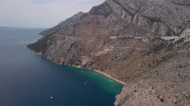 Spektakulärer Blick von einer Höhe des Strandes mit blauem Wasser und schönen Bergen im Hintergrund. Makarska Riviera in Kroatien — Stockvideo