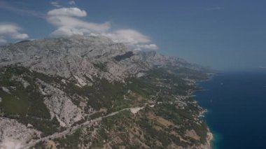 Makarska Riviera 'daki Hırvat kıyılarının yükseklerinden nefes kesici manzaralar. Yolun, dağların, plajların ve yerleşim yerlerinin havadan görünüşü.