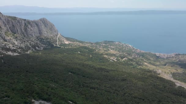 Magas sziklás hegyek hátterében a rendkívül gyönyörű horvát tengerpart. Elhelyezkedés Biokovo Természeti Park — Stock videók