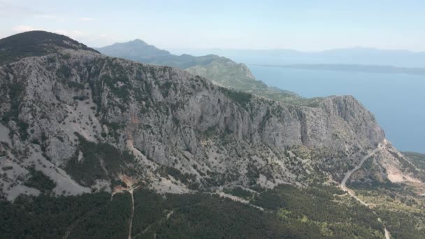 Magas sziklás hegyek hátterében a rendkívül gyönyörű horvát tengerpart. Elhelyezkedés Biokovo Természeti Park — Stock videók