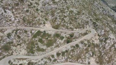 Bisikletçi Hırvatistan 'ın Biokovo Parkı' ndaki dar ve tehlikeli bir dağ yolunda ilerliyor.