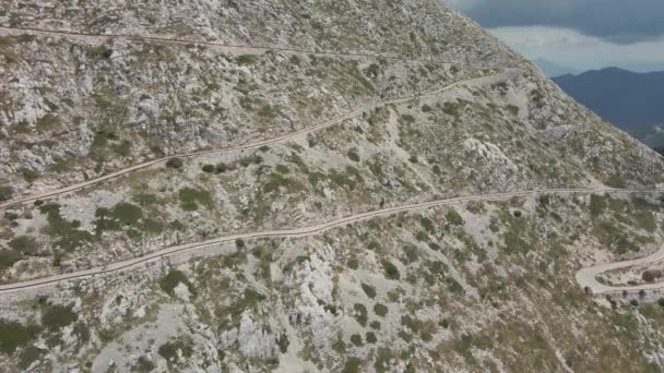 Ο ποδηλάτης κατεβαίνει σε στενό αυτοκινητόδρομο που καταλήγει κατά μήκος της πλαγιάς του ψηλότερου βουνού στο φυσικό πάρκο Biokovo Κροατίας. — Αρχείο Βίντεο